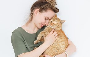 Woman holding an orange cat.