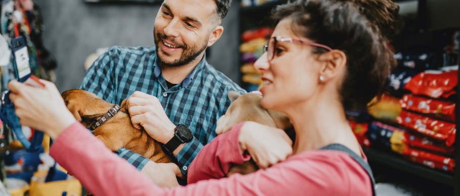 Couple shopping at a pet store holding puppies