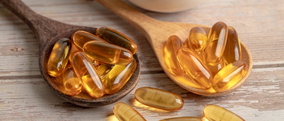 fish oil capsule supplements in a spoon